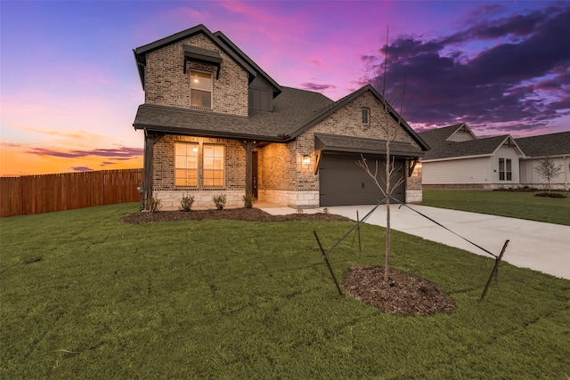 view of front of home with driveway, a garage, fence, a front lawn, and brick siding