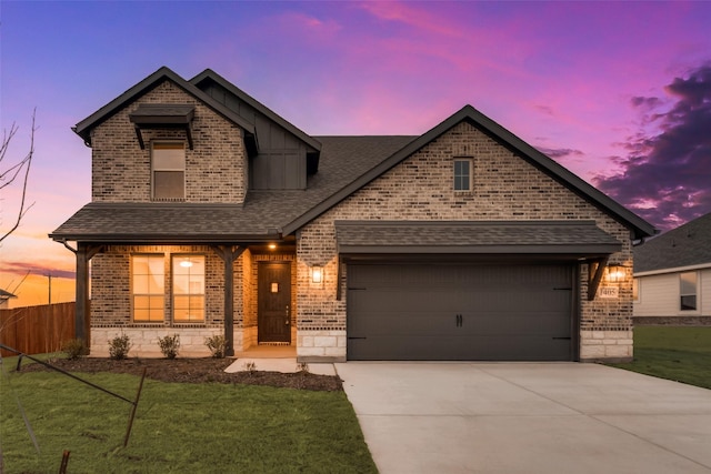 view of front of home with roof with shingles, brick siding, concrete driveway, a garage, and a front lawn