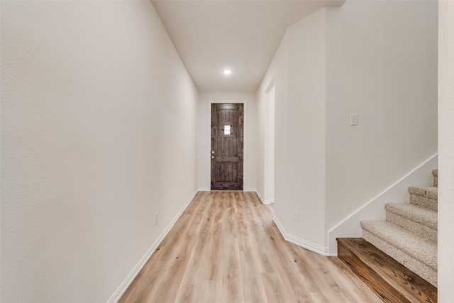 entryway featuring light wood-style flooring, stairway, and baseboards