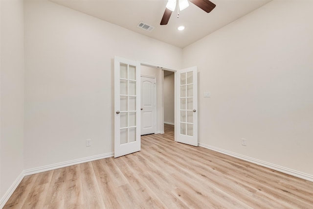 empty room featuring light wood finished floors, french doors, visible vents, and baseboards