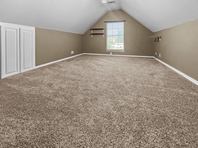 additional living space with carpet flooring and lofted ceiling