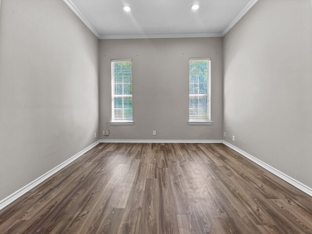 empty room with dark hardwood / wood-style floors and crown molding