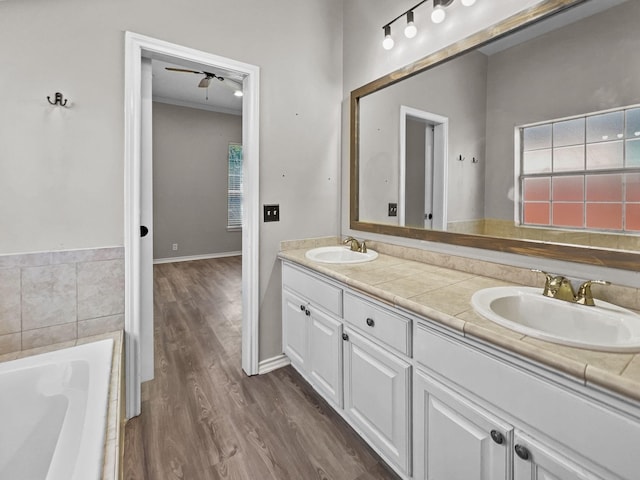 bathroom with ceiling fan, a washtub, vanity, and wood-type flooring