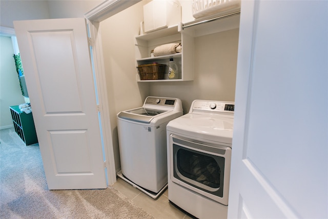 clothes washing area with light carpet and washing machine and clothes dryer