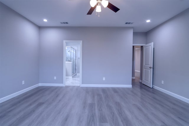 unfurnished bedroom with visible vents, wood finished floors, recessed lighting, connected bathroom, and baseboards