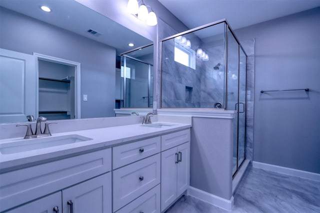 bathroom with a shower stall, baseboards, visible vents, and a sink