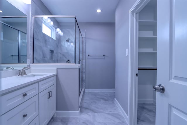 bathroom with vanity, baseboards, and a stall shower
