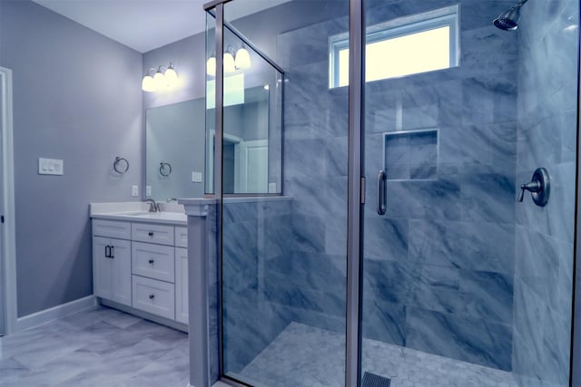 bathroom with baseboards, vanity, and a shower stall