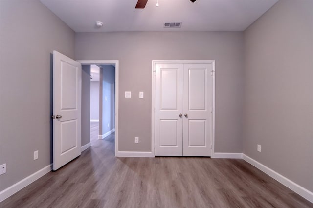 unfurnished bedroom with visible vents, baseboards, and wood finished floors