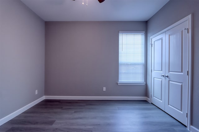 unfurnished bedroom featuring a closet and dark hardwood / wood-style flooring