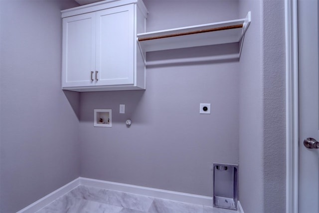 clothes washing area featuring electric dryer hookup, washer hookup, cabinet space, baseboards, and gas dryer hookup