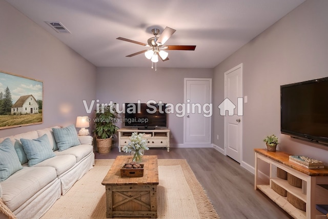living room featuring visible vents, baseboards, a ceiling fan, and wood finished floors
