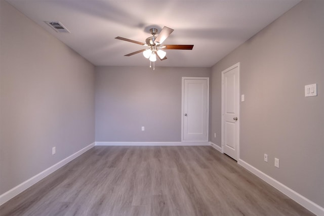 empty room featuring visible vents, baseboards, ceiling fan, and wood finished floors