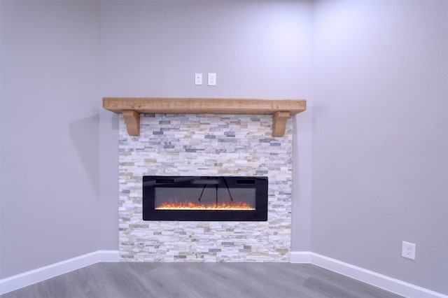 details with a fireplace, wood finished floors, and baseboards