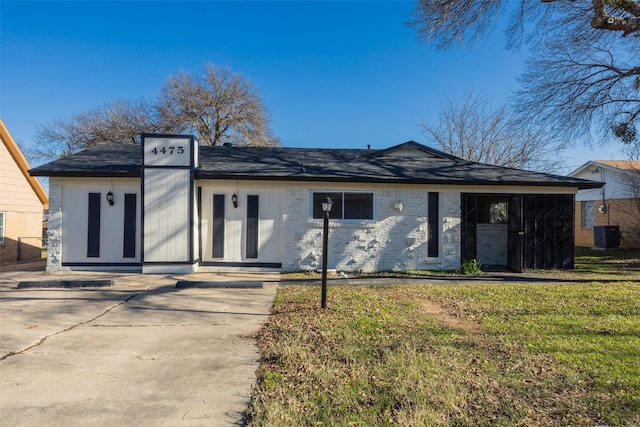 ranch-style house with cooling unit and a front lawn