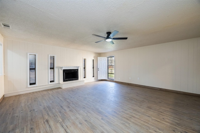 unfurnished living room with hardwood / wood-style floors, ceiling fan, and a textured ceiling