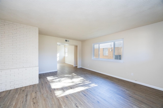 spare room with dark hardwood / wood-style flooring and a textured ceiling