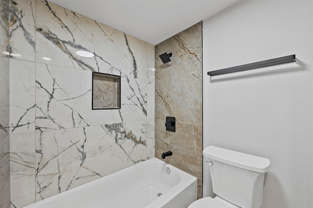 bathroom featuring tiled shower / bath combo and toilet