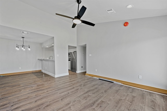 interior space with ceiling fan, light wood-type flooring, sink, and high vaulted ceiling