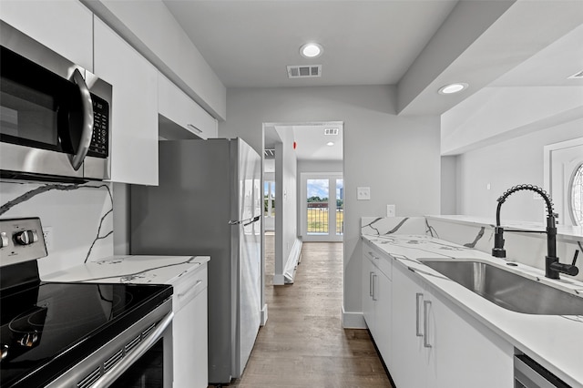 kitchen with stainless steel appliances, white cabinetry, dark hardwood / wood-style floors, and sink