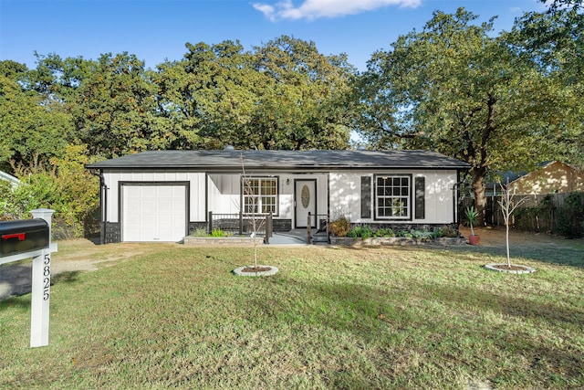 ranch-style home with covered porch, a front yard, and a garage