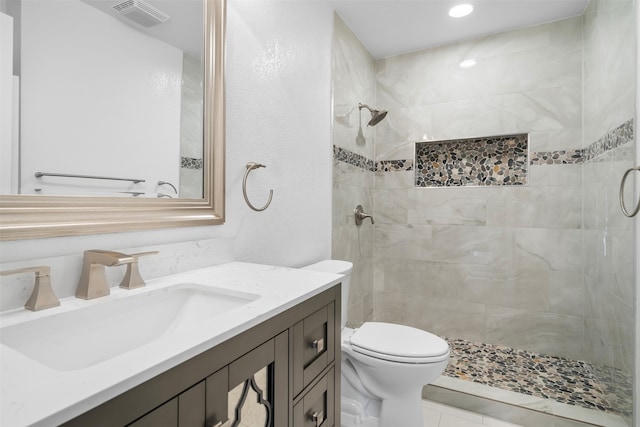 bathroom featuring tile patterned flooring, vanity, toilet, and an enclosed shower