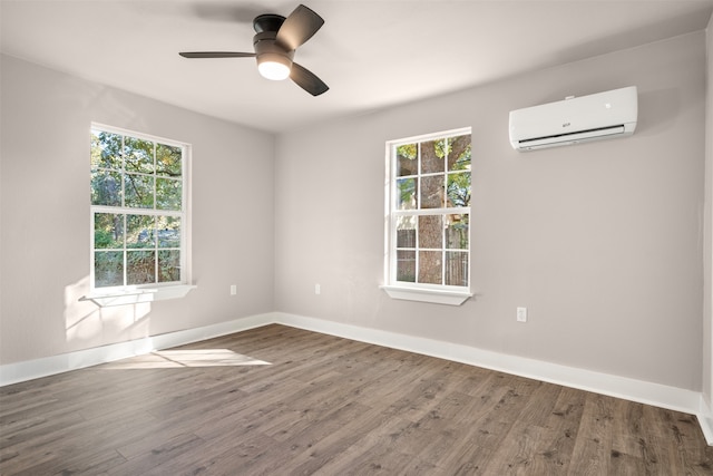 spare room with hardwood / wood-style flooring, plenty of natural light, and a wall mounted AC