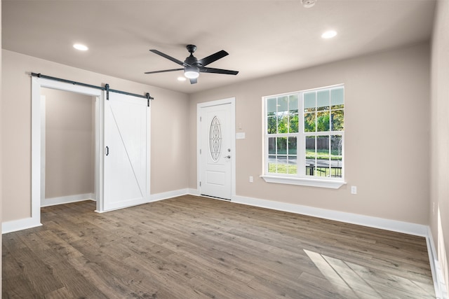 foyer featuring a barn door, ceiling fan, and hardwood / wood-style floors