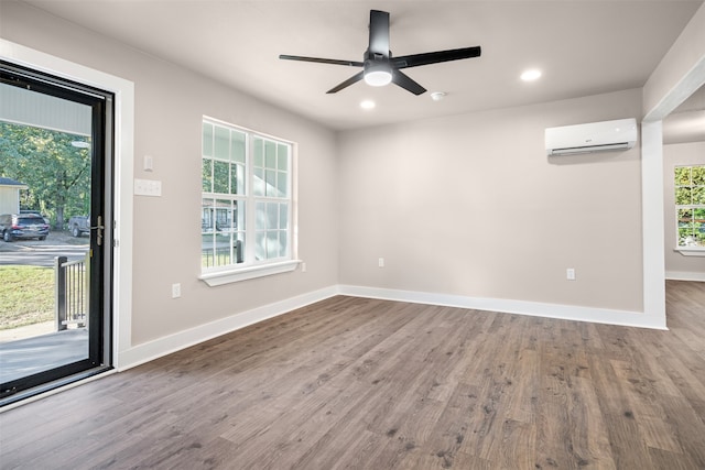 empty room with ceiling fan, hardwood / wood-style floors, and a wall mounted air conditioner