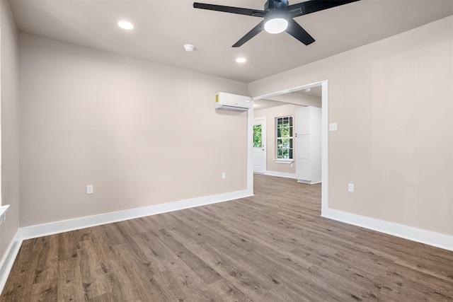 unfurnished room featuring hardwood / wood-style flooring, ceiling fan, and a wall unit AC