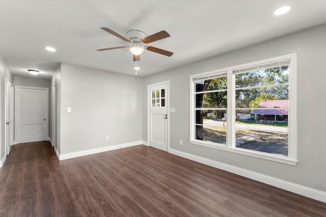 spare room featuring ceiling fan and dark wood-type flooring