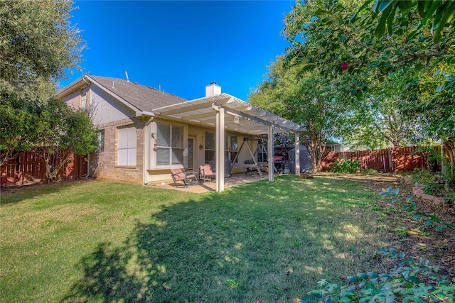 rear view of property with a yard, a pergola, and a patio area