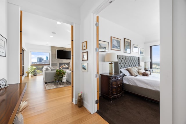 bedroom featuring light wood-type flooring and a fireplace