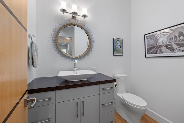 bathroom featuring wood-type flooring, vanity, and toilet