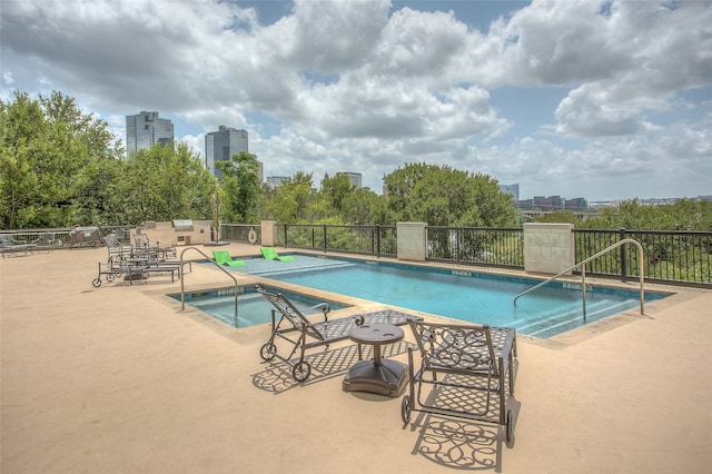 view of swimming pool with a patio area and a community hot tub