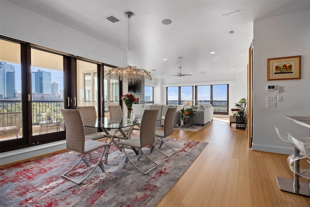 dining area with ceiling fan and light wood-type flooring