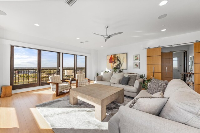 living room featuring light hardwood / wood-style floors and ceiling fan