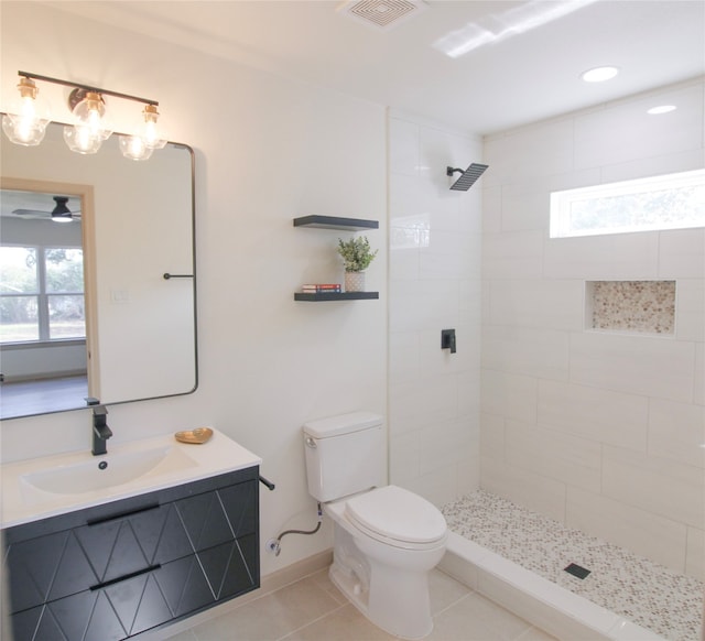 bathroom with tile patterned floors, vanity, toilet, and a wealth of natural light