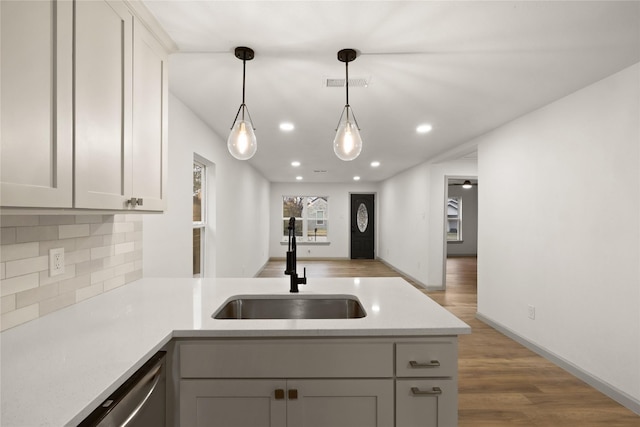 kitchen with sink, gray cabinetry, tasteful backsplash, pendant lighting, and hardwood / wood-style floors