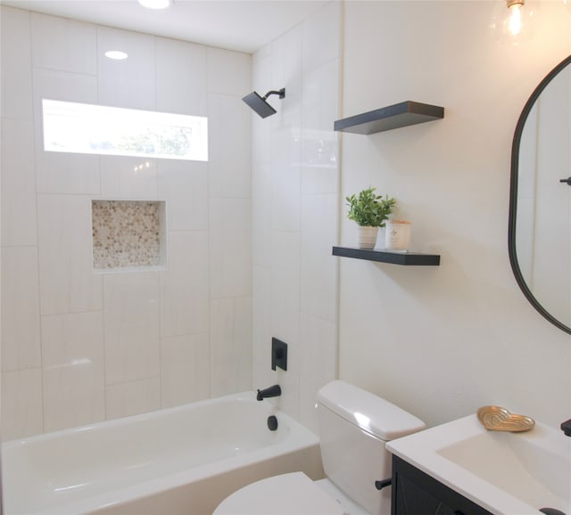 full bathroom featuring vanity, tiled shower / bath combo, and toilet