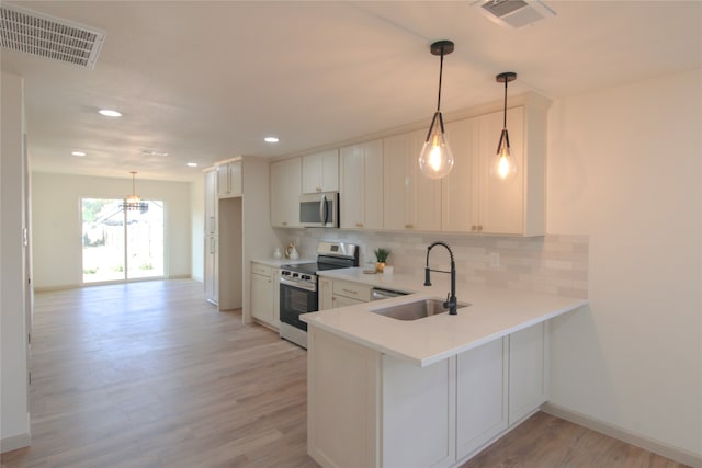 kitchen featuring kitchen peninsula, light wood-type flooring, stainless steel appliances, and sink