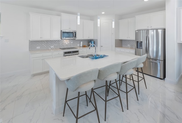 kitchen featuring white cabinetry, sink, a center island with sink, and appliances with stainless steel finishes