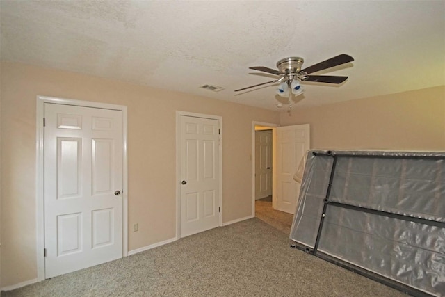 unfurnished bedroom with carpet flooring, a textured ceiling, and ceiling fan