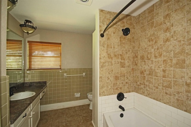 full bathroom featuring vanity, tile walls, tile patterned flooring, toilet, and tiled shower / bath