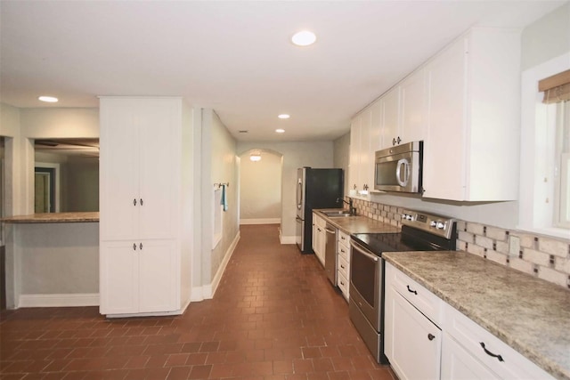 kitchen featuring tasteful backsplash, sink, white cabinets, and stainless steel appliances