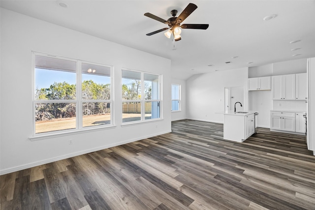 unfurnished living room with ceiling fan, dark wood-type flooring, and sink