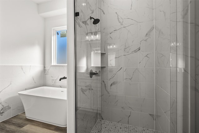 bathroom with plus walk in shower, wood-type flooring, and tile walls