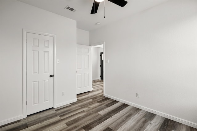 unfurnished bedroom featuring ceiling fan and dark hardwood / wood-style floors