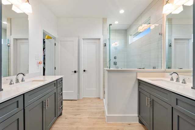 bathroom with wood-type flooring, vanity, and a shower with shower door