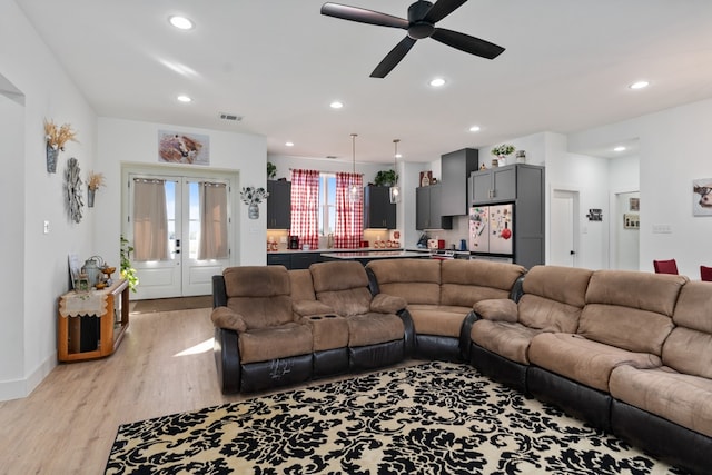 living room featuring ceiling fan, french doors, and light hardwood / wood-style flooring